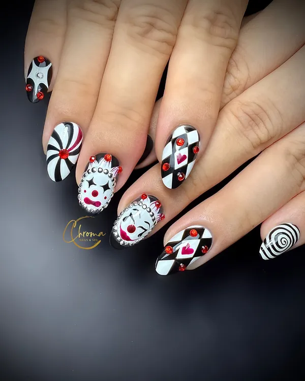 Black and white almond nails with creepy clown faces, harlequin diamonds and red gems